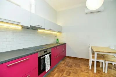 a kitchen with pink cabinets and a table in it at Athens Sea view 2 floor apartment next to Marina in Athens