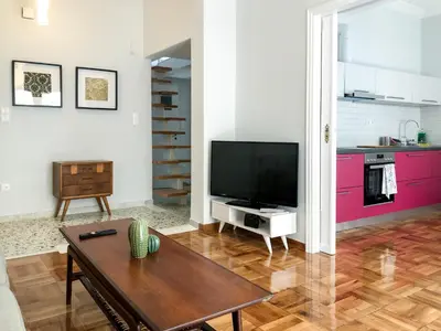 a living room with a tv and a table at Athens Sea view 2 floor apartment next to Marina in Athens