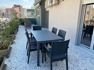 a black table and chairs on a balcony at ASIMINA apartment, Kerameikos Metro Station in Athens