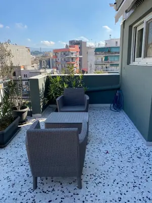a patio with two chairs and a couch on a balcony at ASIMINA apartment, Kerameikos Metro Station in Athens