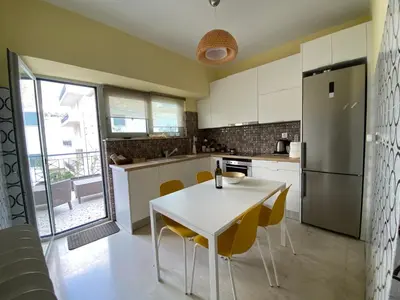 a kitchen with a white table and yellow chairs at ASIMINA apartment, Kerameikos Metro Station in Athens