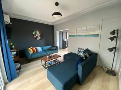 a living room with two blue couches and a table at ASIMINA apartment, Kerameikos Metro Station in Athens
