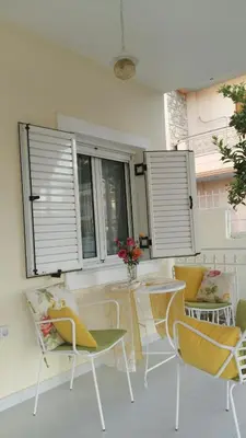 a patio with chairs and a table and windows at NN Spata Rooms & Suites near Athens airport in Spáta