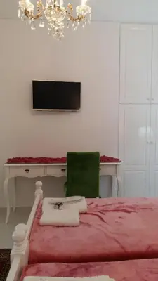 a bedroom with a bed with a desk and a green chair at NN Spata Rooms & Suites near Athens airport in Spáta
