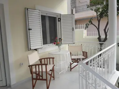 a balcony with a table and chairs and a window at NN Spata Rooms & Suites near Athens airport in Spáta