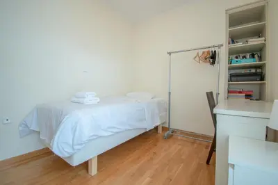 a bedroom with a white bed and a mirror at Homey Penthouse in Kypseli in Athens