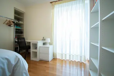 a bedroom with a bed and a desk and a window at Homey Penthouse in Kypseli in Athens