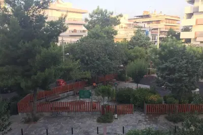 a garden with a red fence in front of a building at Two Bedroom Apartment Near Alimos Marina ! in Athens