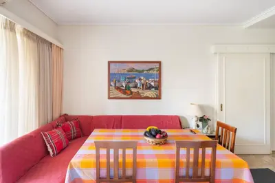 a living room with a red couch and a table at Two Bedroom Apartment Near Alimos Marina ! in Athens