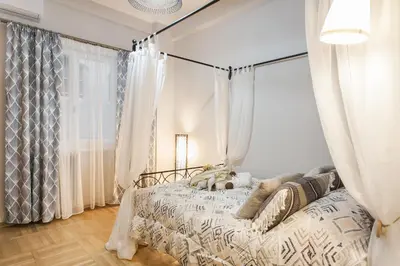 a bedroom with a bed with white curtains at Syntagma 3 Bedroom Sweet Simple And Practical Apartment in Athens