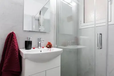 a white bathroom with a sink and a shower at Syntagma 3 Bedroom Sweet Simple And Practical Apartment in Athens