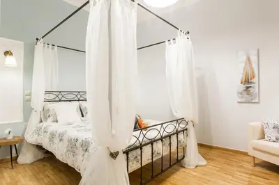 a bedroom with a canopy bed with white curtains at Syntagma 3 Bedroom Sweet Simple And Practical Apartment in Athens