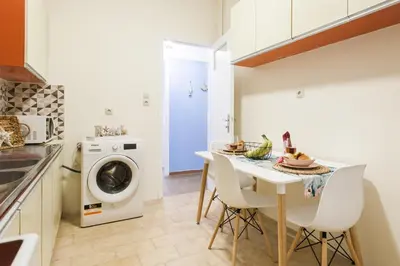a kitchen with a table and a washing machine at Cozy, Central, Safe apartment close to Acropolis in Athens