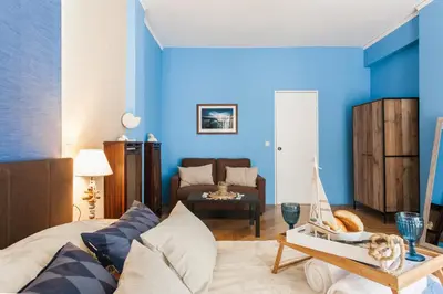 a living room with blue walls and a bed with a toy boat on a table at Cozy, Central, Safe apartment close to Acropolis in Athens