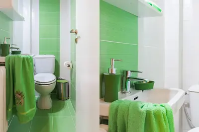 a green and white bathroom with a toilet and a sink at Museum of Modern Apartment next to Suggrou Fix metro- big, safe, simple and central in Athens