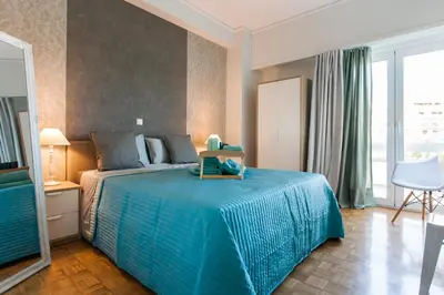 a bedroom with a bed with a blue bedspread at Museum of Modern Apartment next to Suggrou Fix metro- big, safe, simple and central in Athens