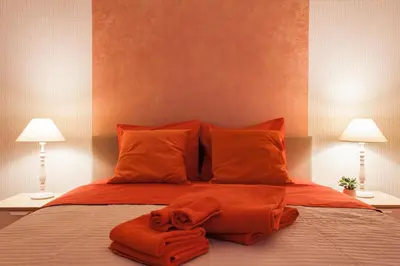a bed with two towels on it with two lamps at Museum of Modern Apartment next to Suggrou Fix metro- big, safe, simple and central in Athens