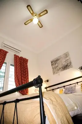 a bedroom with a bed with a ceiling fan at Aroura Homes Garden House 2BR 2BA Free Parking in Athens