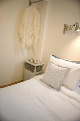 a bedroom with a white bed and a night stand at Aroura Homes Garden House 2BR 2BA Free Parking in Athens