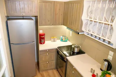 a kitchen with a stainless steel refrigerator and wooden cabinets at Aroura Homes Garden House 2BR 2BA Free Parking in Athens