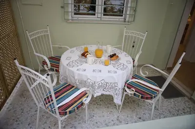 a white table with chairs and orange juice on it at Aroura Homes Garden House 2BR 2BA Free Parking in Athens