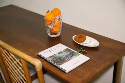 a table with a book and a plate of oranges at Aroura Homes Garden House 2BR 2BA Free Parking in Athens