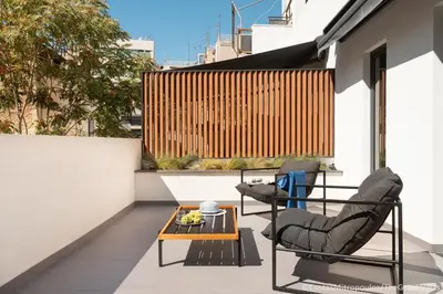 a patio with two chairs and a table on a balcony at 11 Enteka Acropolis Suites in Athens