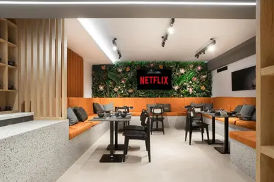 a restaurant with tables and chairs and a sign that reads netflix at 11 Enteka Acropolis Suites in Athens