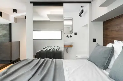 a bedroom with a bed and a toilet and a window at 11 Enteka Acropolis Suites in Athens