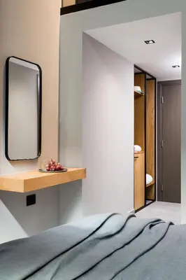 a mirror on a wall next to a bed at 11 Enteka Acropolis Suites in Athens