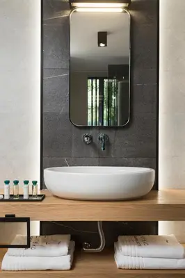 a bathroom with a white sink and a mirror at 11 Enteka Acropolis Suites in Athens