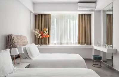 a hotel room with two beds and a window at The Square Six in Athens