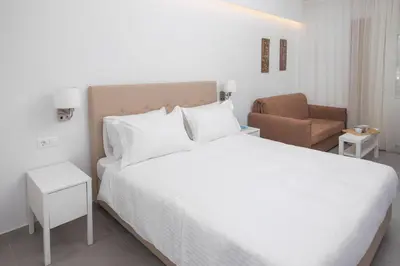 a bedroom with a large white bed and a chair at The Square Six in Athens