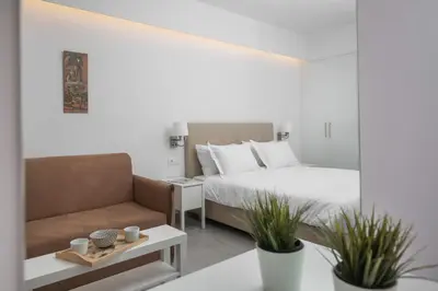a bedroom with a bed and a chair and a mirror at The Square Six in Athens