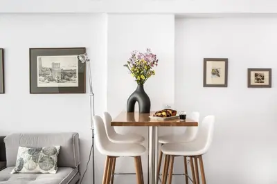 a dining room with a table and a vase with flowers at The Square Six in Athens