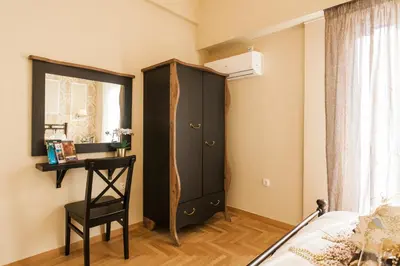 a bedroom with a black cabinet and a chair at A Modern Antique Central 3 Bedroom Simple Apartment near to Acropolis in Athens
