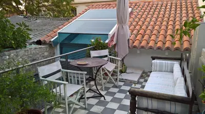 a balcony with a table and chairs on a roof at Under the Acropolis, tiny room, big terrace in Athens