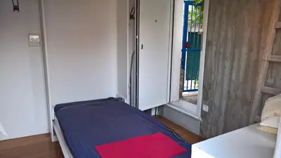 a bed in a room with an open door at Under the Acropolis, tiny room, big terrace in Athens