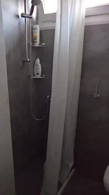 a bathroom with a shower with a shower curtain at Under the Acropolis, tiny room, big terrace in Athens