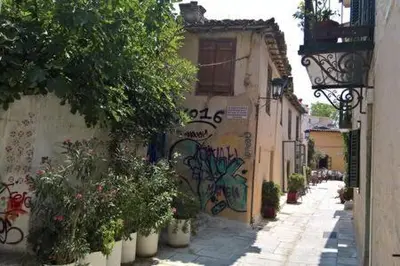 an alley with graffiti on the side of a building at Under the Acropolis, tiny room, big terrace in Athens