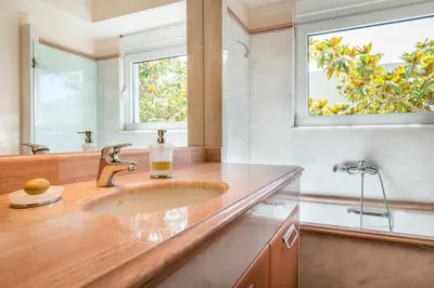 a bathroom with a sink and two windows at Amazing 5 bedroom Villa with Swimming Pool in Athens