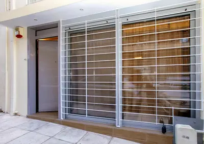 a room with a large window with blinds at Modern hospitality, with private garden, Athens in Athens