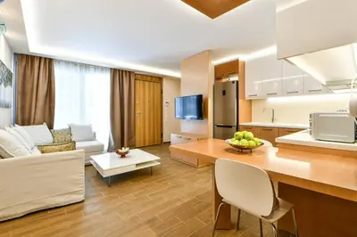 a kitchen and living room with a couch and a table at Modern hospitality, with private garden, Athens in Athens