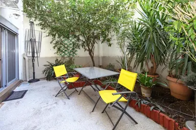 a table and chairs in a courtyard with plants at Modern hospitality, with private garden, Athens in Athens