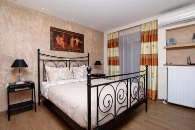a bedroom with a bed and a painting on the wall at Modern hospitality, with private garden, Athens in Athens