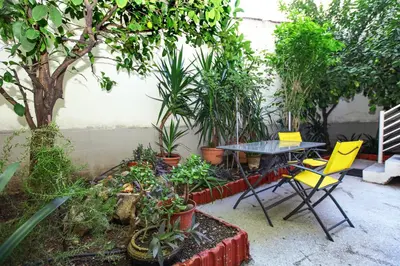 a patio with a table and chairs and plants at Modern hospitality, with private garden, Athens in Athens