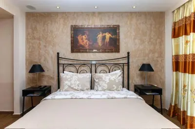 a bedroom with a large bed with two nightstands and two lamps at Modern hospitality, with private garden, Athens in Athens