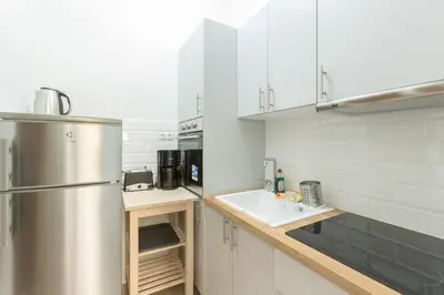 a kitchen with white cabinets and a stainless steel refrigerator at Cozy Flat with Terrace & Patio, next to Lycabettus in Athens