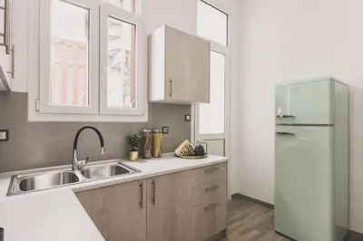 a kitchen with a sink and a refrigerator at Neoclassical Apartment near Acropolis - LivingStone Crystal in Athens