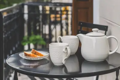 a table with two cups and a plate of orange slices at Neoclassical Apartment near Acropolis - LivingStone Crystal in Athens